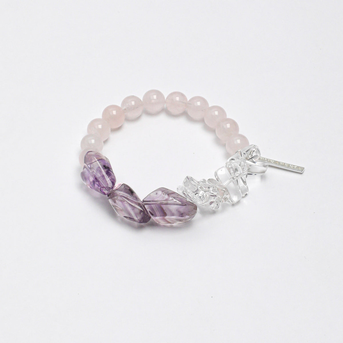 Handcrafted stretch bracelet featuring natural Rose Quartz beads, carved Amethyst leaf gemstones, Clear Quartz crystal chips, and a silver tassel charm on a durable elastic band.