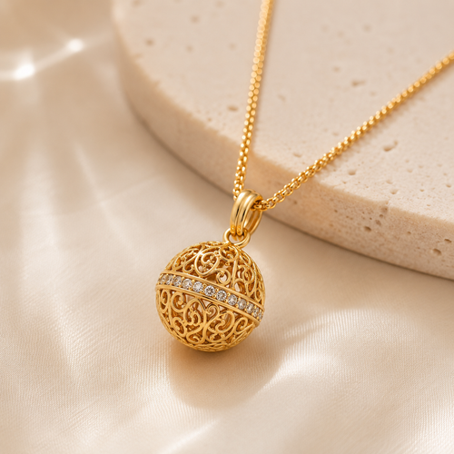 Close-up of 18K gold plated 925 sterling silver Harmony Ball necklace with ornate filigree detailing and sparkling accents