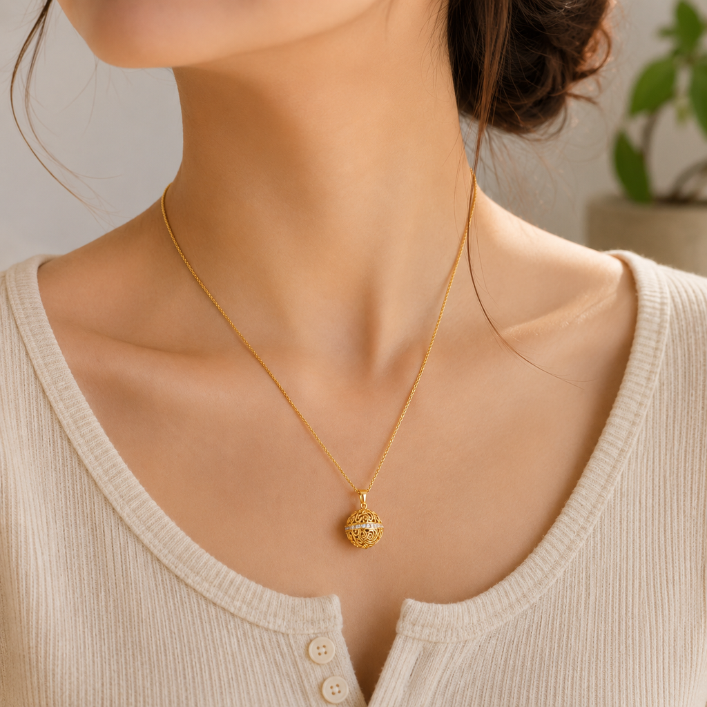 18K gold plated 925 sterling silver Harmony Ball pendant necklace worn with a neutral everyday outfit
