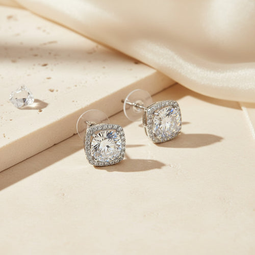 925 sterling silver cushion halo moissanite stud earrings displayed in soft natural sunlight, showcasing brilliant sparkle, rainbow fire, and an elegant vintage-inspired halo design.