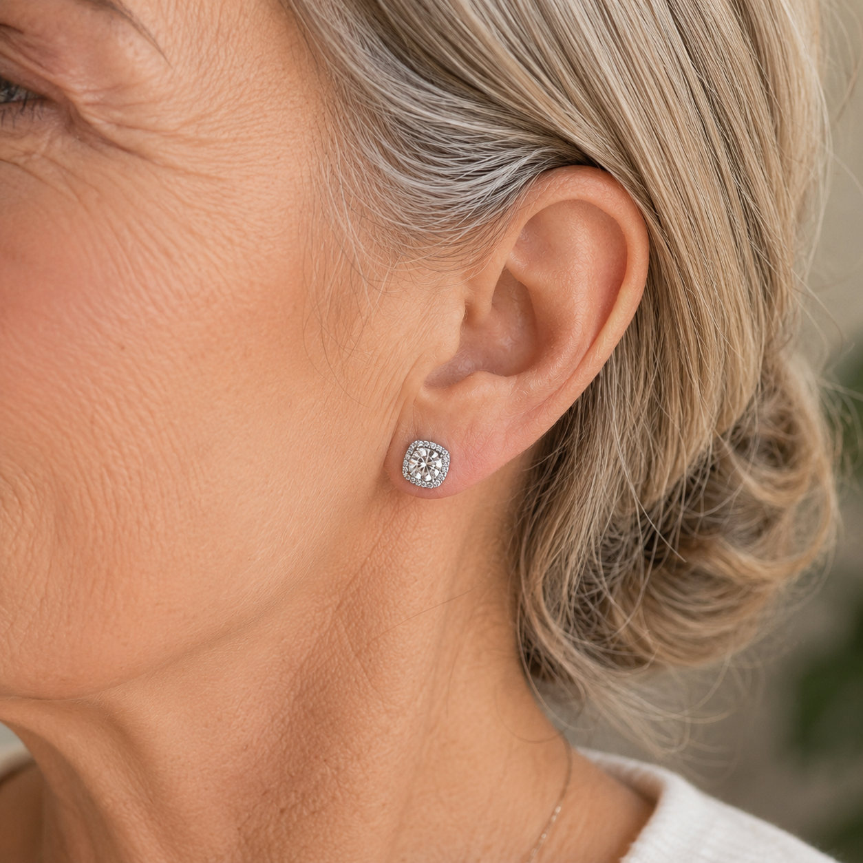 Woman wearing 925 sterling silver cushion halo moissanite stud earrings in a close-up lifestyle view