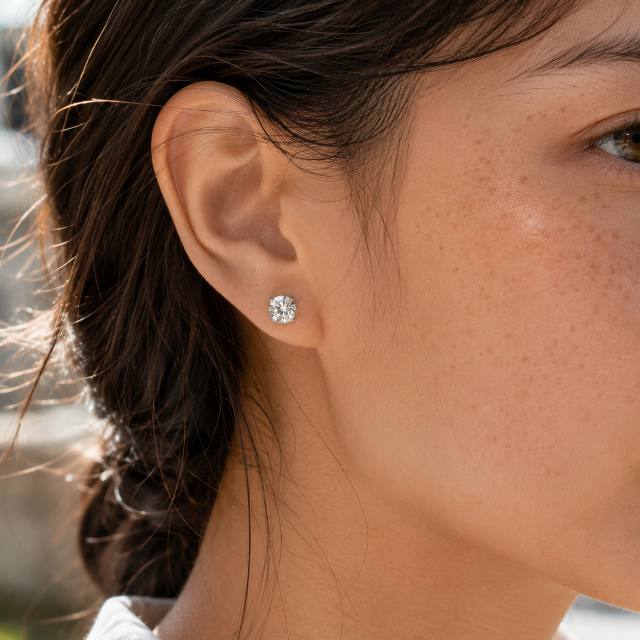 Close-up of the right ear wearing 925 sterling silver round moissanite stud earrings