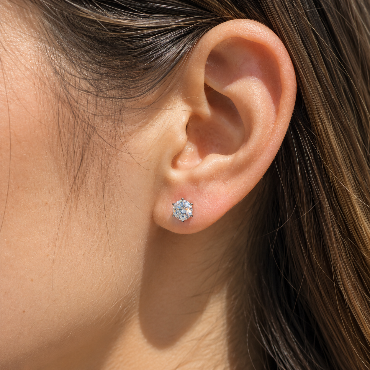 925 sterling silver six-prong moissanite stud earring worn on left ear