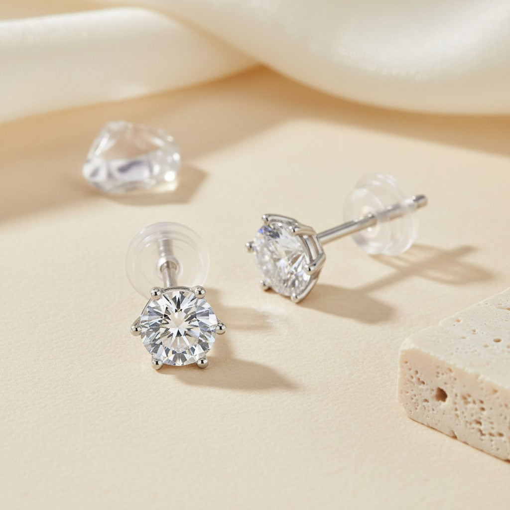 925 sterling silver six-prong moissanite stud earrings displayed in a warm neutral jewellery setting