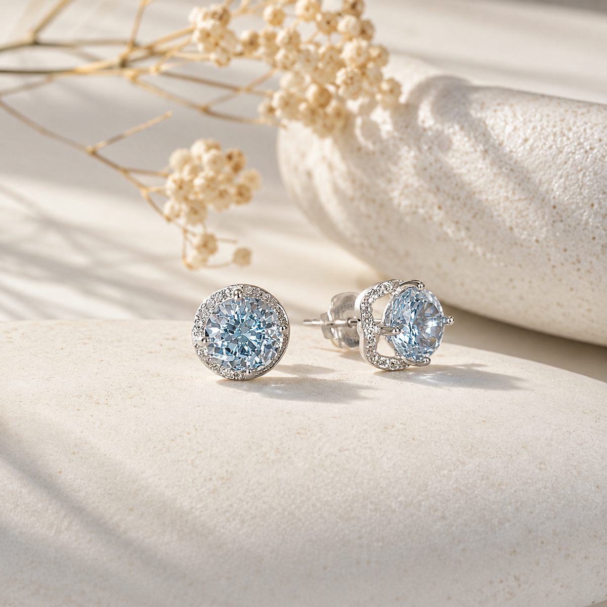 Blue CZ snowflake-cut stud earrings styled in soft natural light on a neutral surface.