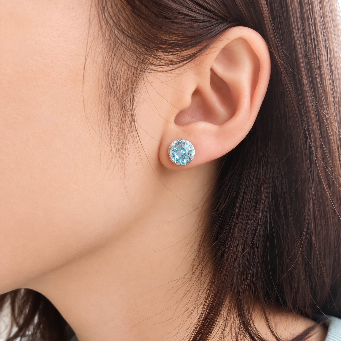 Blue CZ snowflake-cut stud earring worn on the ear, showing its delicate snowflake design and sparkle