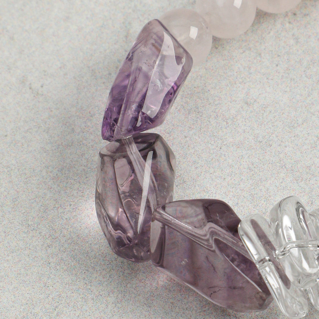 Close-up of faceted amethyst gemstone accents on handmade rose quartz bracelet