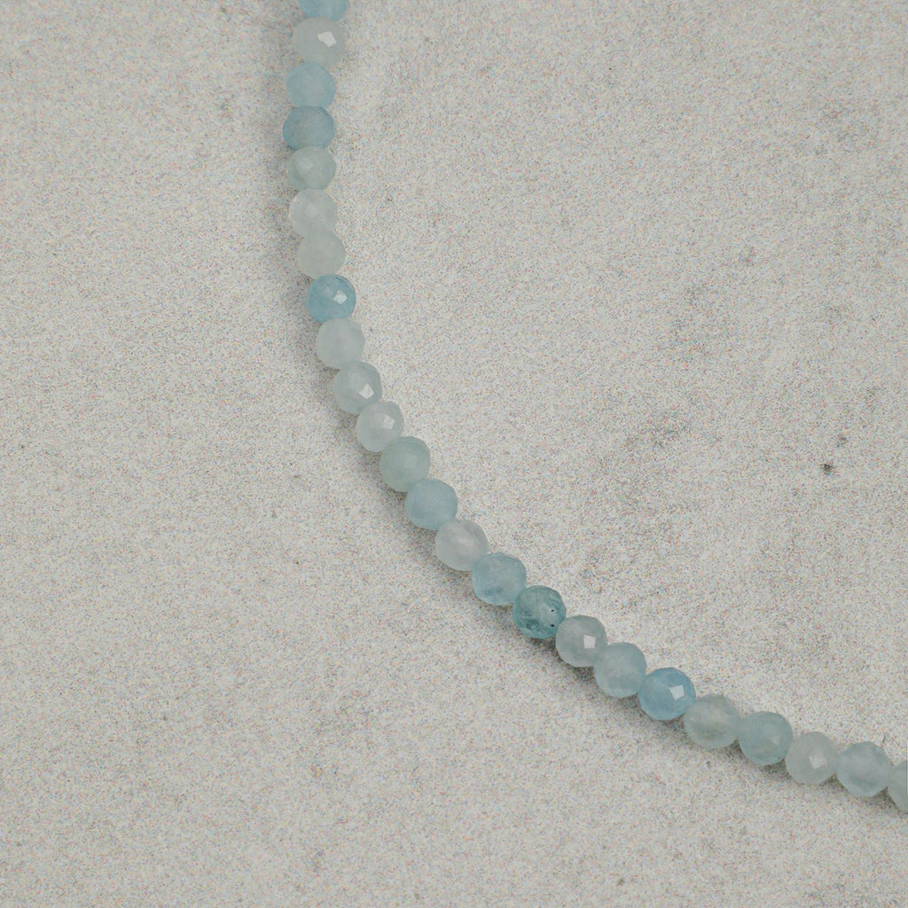 Close-up of faceted aquamarine beads on layered gemstone bracelet