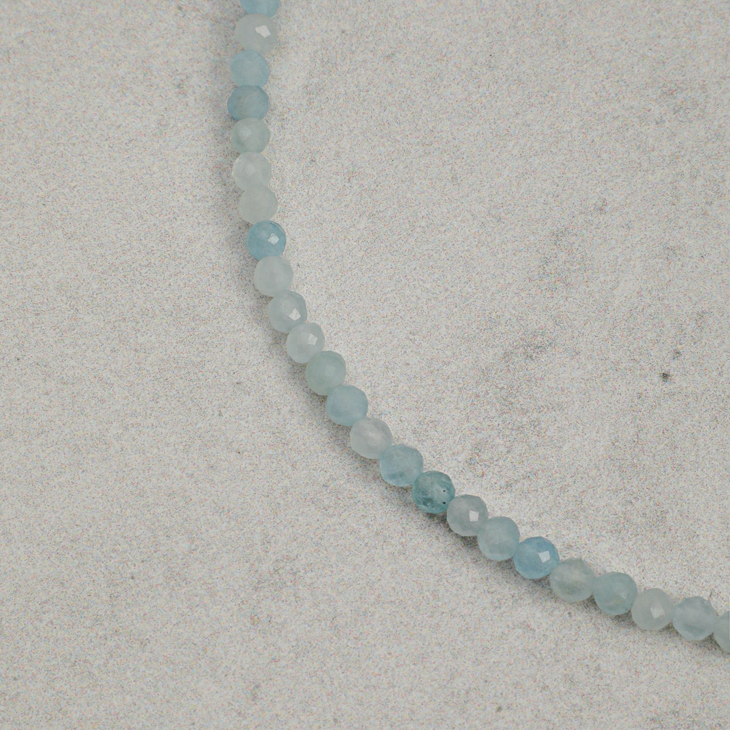 Close-up of faceted aquamarine beads on layered gemstone bracelet