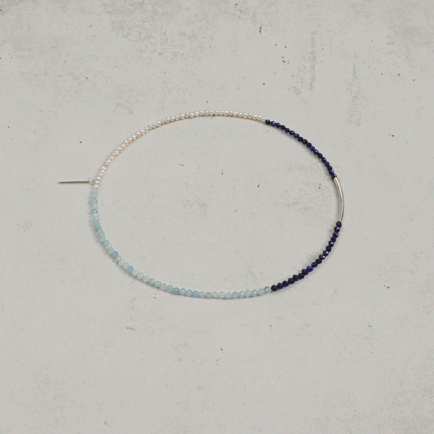 Open view of aquamarine, lapis lazuli and freshwater pearl layered bracelet with silver accent