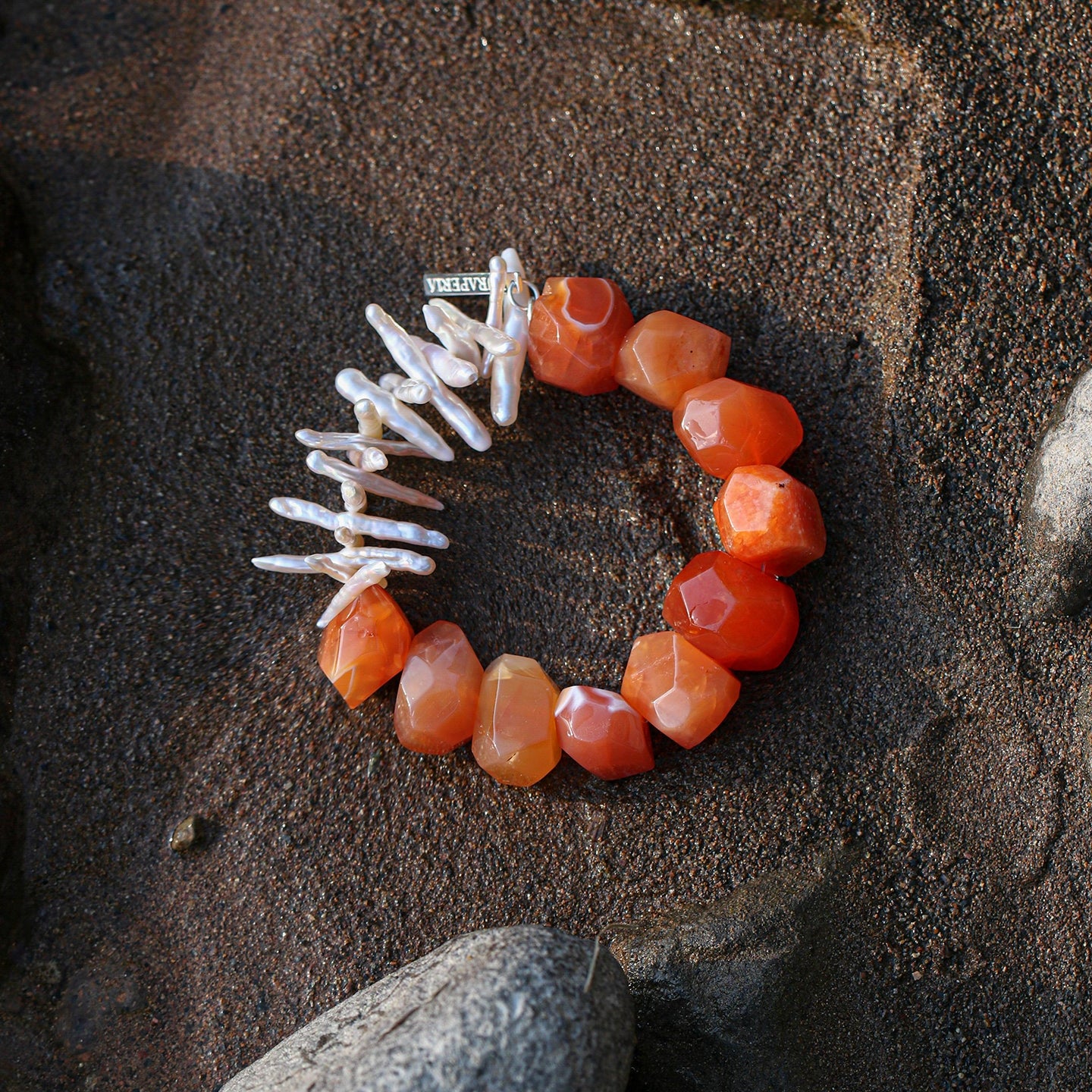 Carnelian and elongated freshwater pearl statement bracelet styled on natural rock