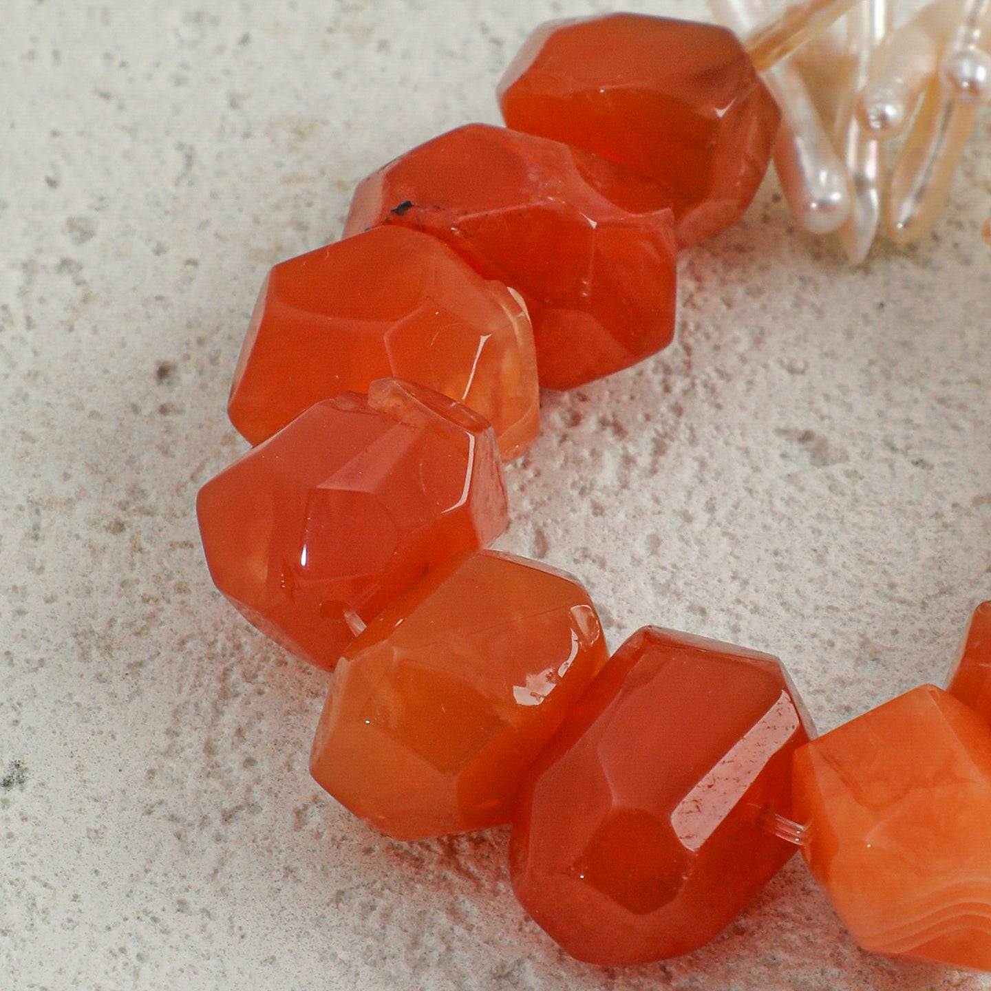 Close-up of faceted natural carnelian gemstones on handcrafted statement bracelet