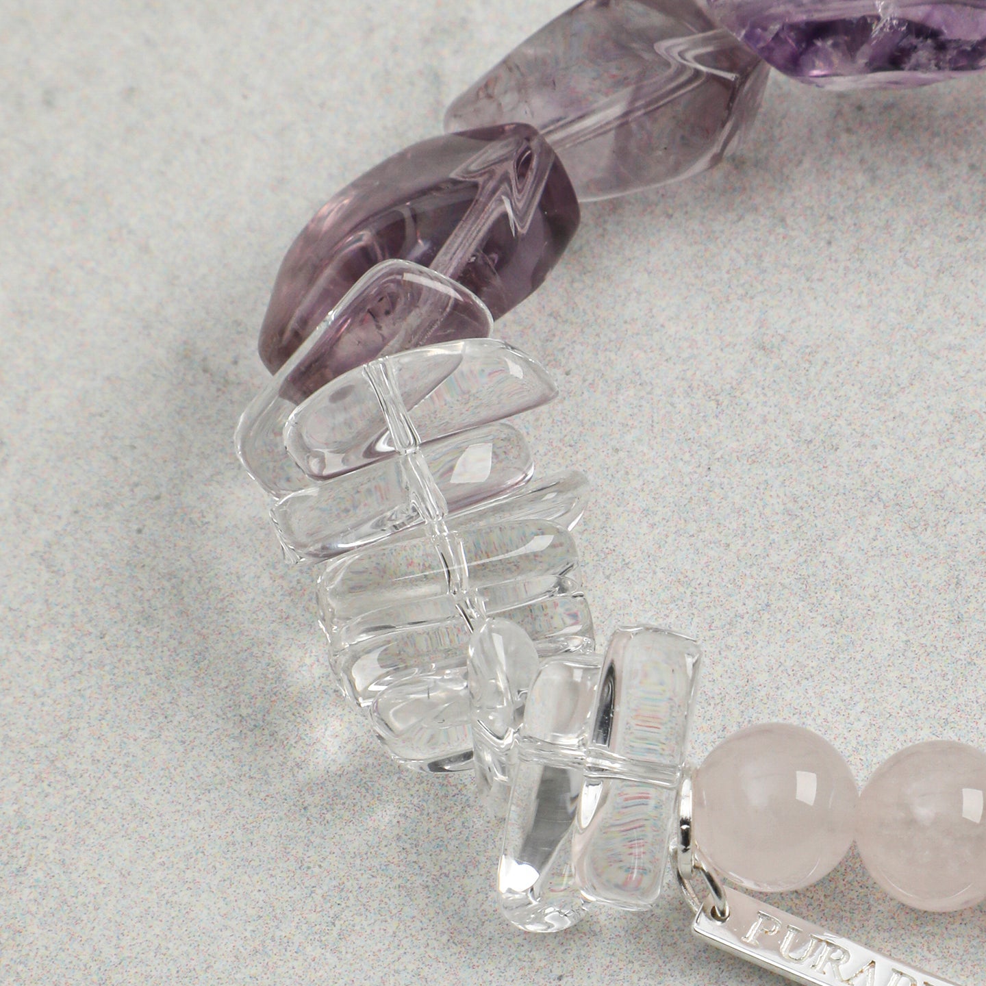 Close-up of clear quartz gemstone accents on handmade rose quartz and amethyst bracelet