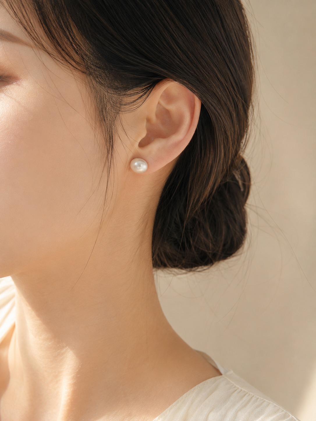Close-up of a model wearing 10mm freshwater pearl stud earrings