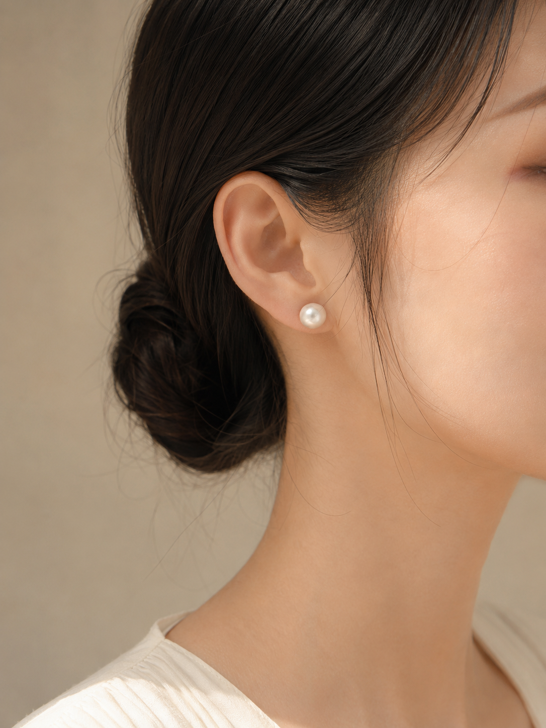 Close-up of a model wearing 10mm freshwater pearl stud earrings right ear