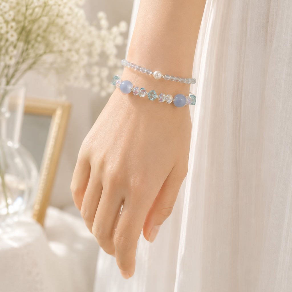 Close-up of a woman wearing a handmade natural aquamarine bracelet featuring 4mm aquamarine beads, an 8mm genuine freshwater pearl and silver-tone spacer beads.