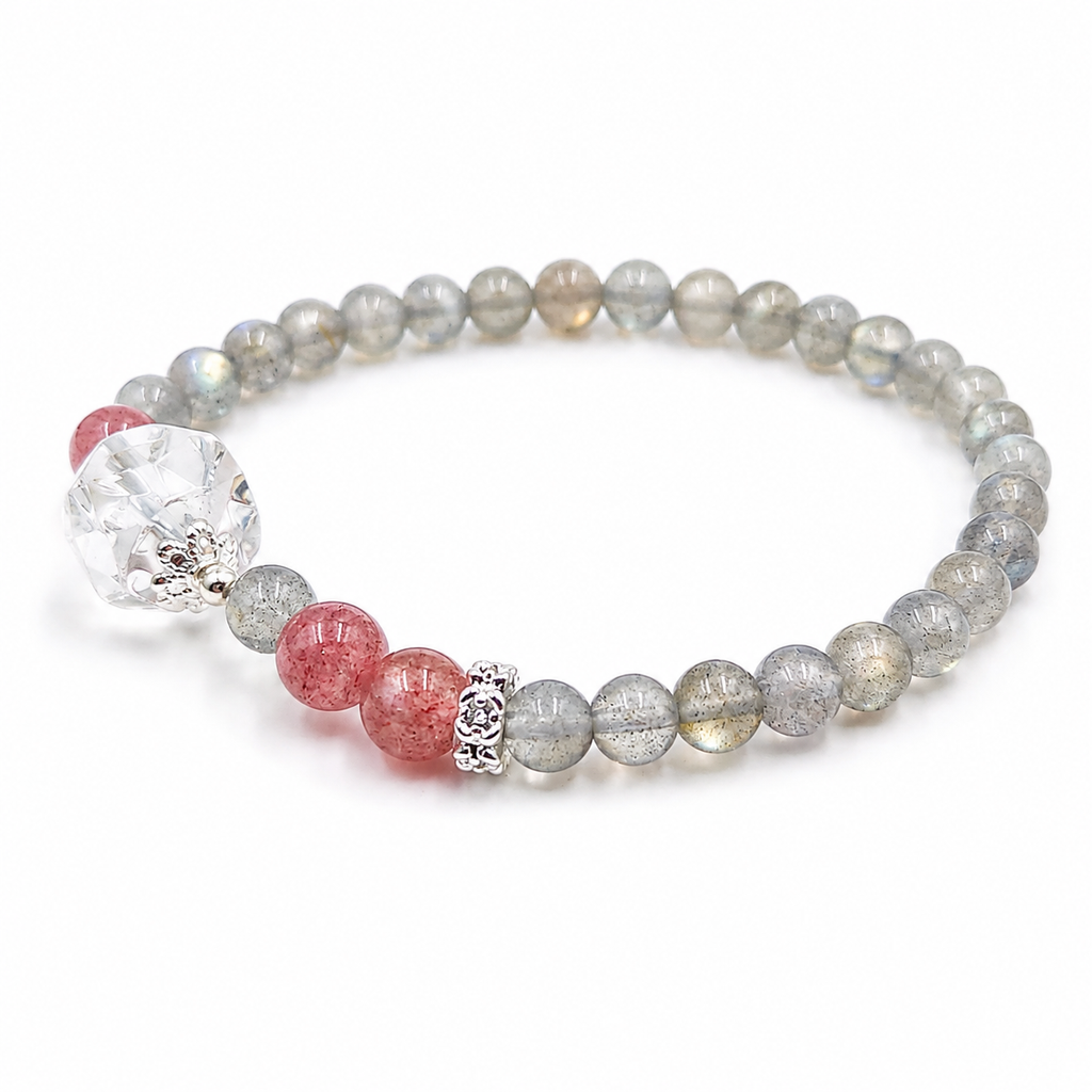 Handmade natural grey moonstone bracelet featuring 4mm grey moonstone beads, a freeform clear quartz focal bead, strawberry quartz accent beads and silver-tone spacer beads on a white background.