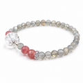 Handmade natural grey moonstone bracelet featuring 4mm grey moonstone beads, a freeform clear quartz focal bead, strawberry quartz accent beads and silver-tone spacer beads on a white background.