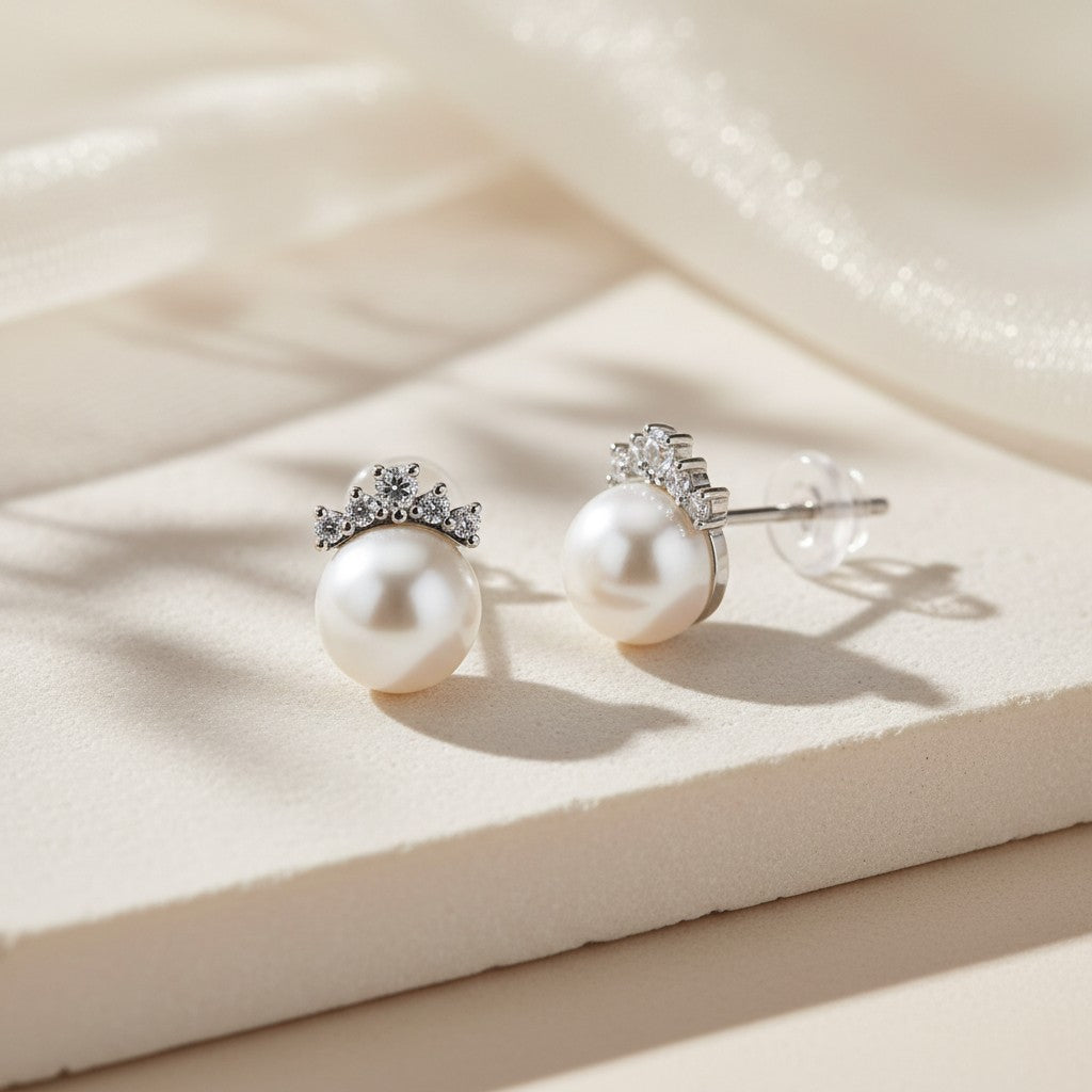 Pearl Crown stud earrings in 925 sterling silver with cubic zirconia accents displayed on a warm neutral surface