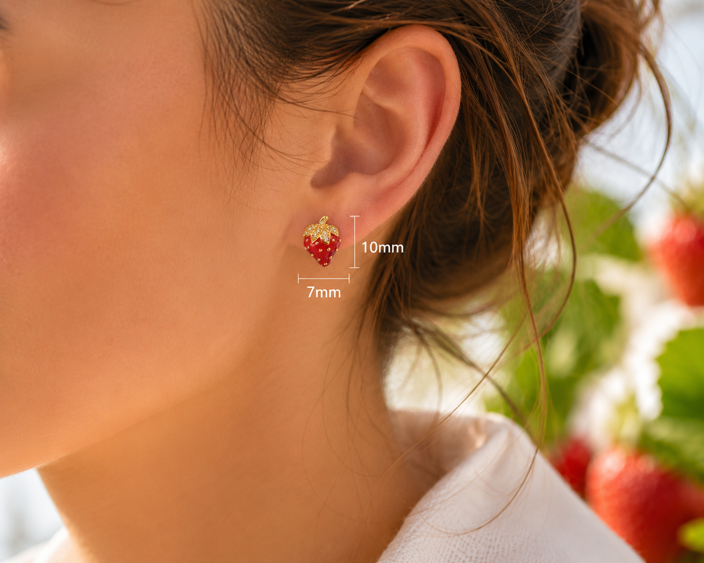 Red strawberry gold-tone stud earring worn on ear showing 10 mm height and 7 mm width