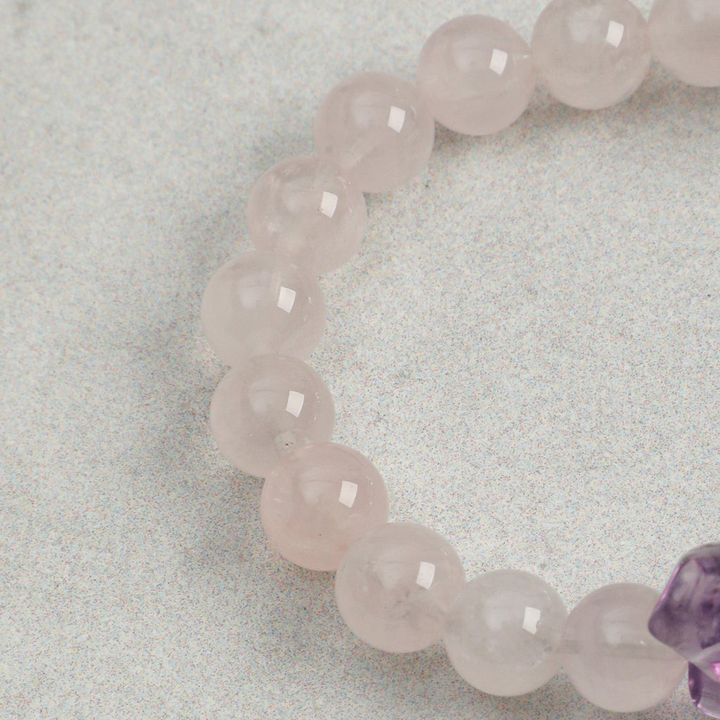 Close-up of polished rose quartz beads on handmade gemstone bracelet