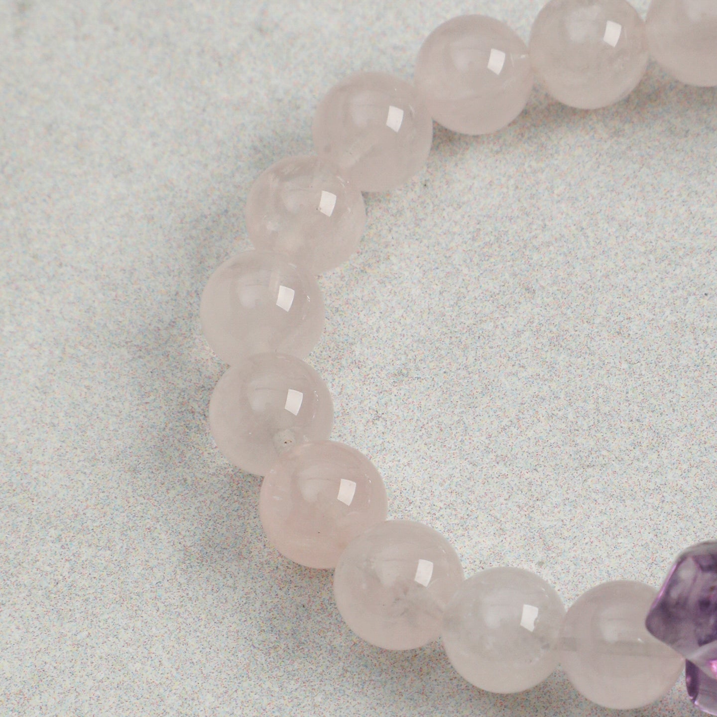 Close-up of polished rose quartz beads on handmade gemstone bracelet