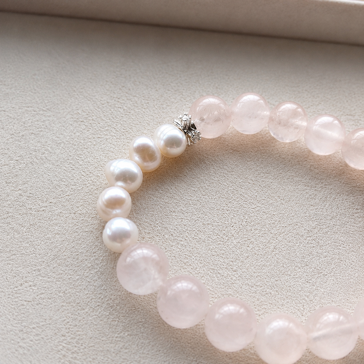 Close-up detail of rose quartz and freshwater pearls on bracelet