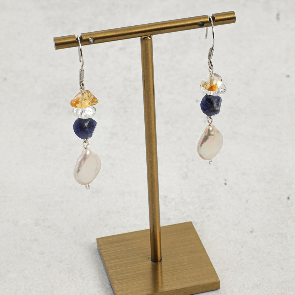 Sodalite, citrine and freshwater pearl drop earrings displayed on a brass jewellery stand