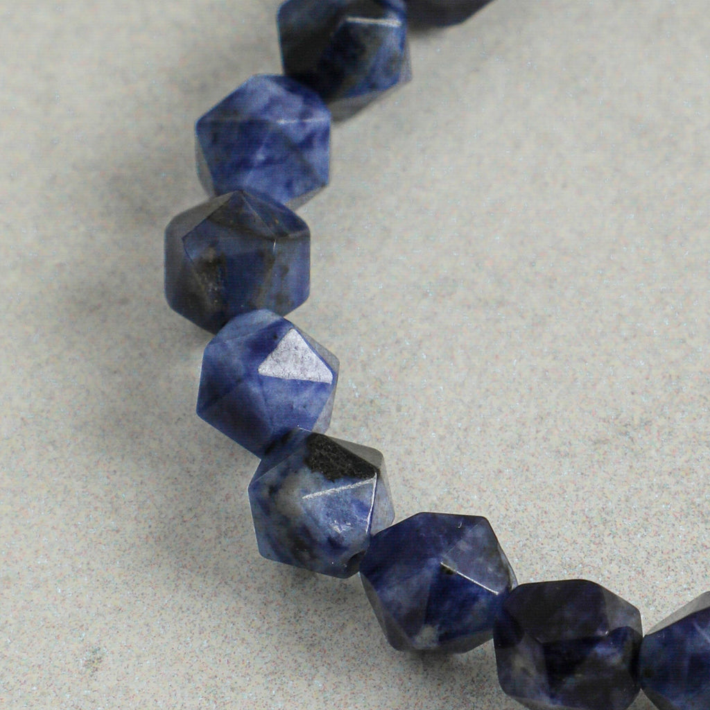 Close-up of faceted natural sodalite gemstones on handcrafted statement bracelet