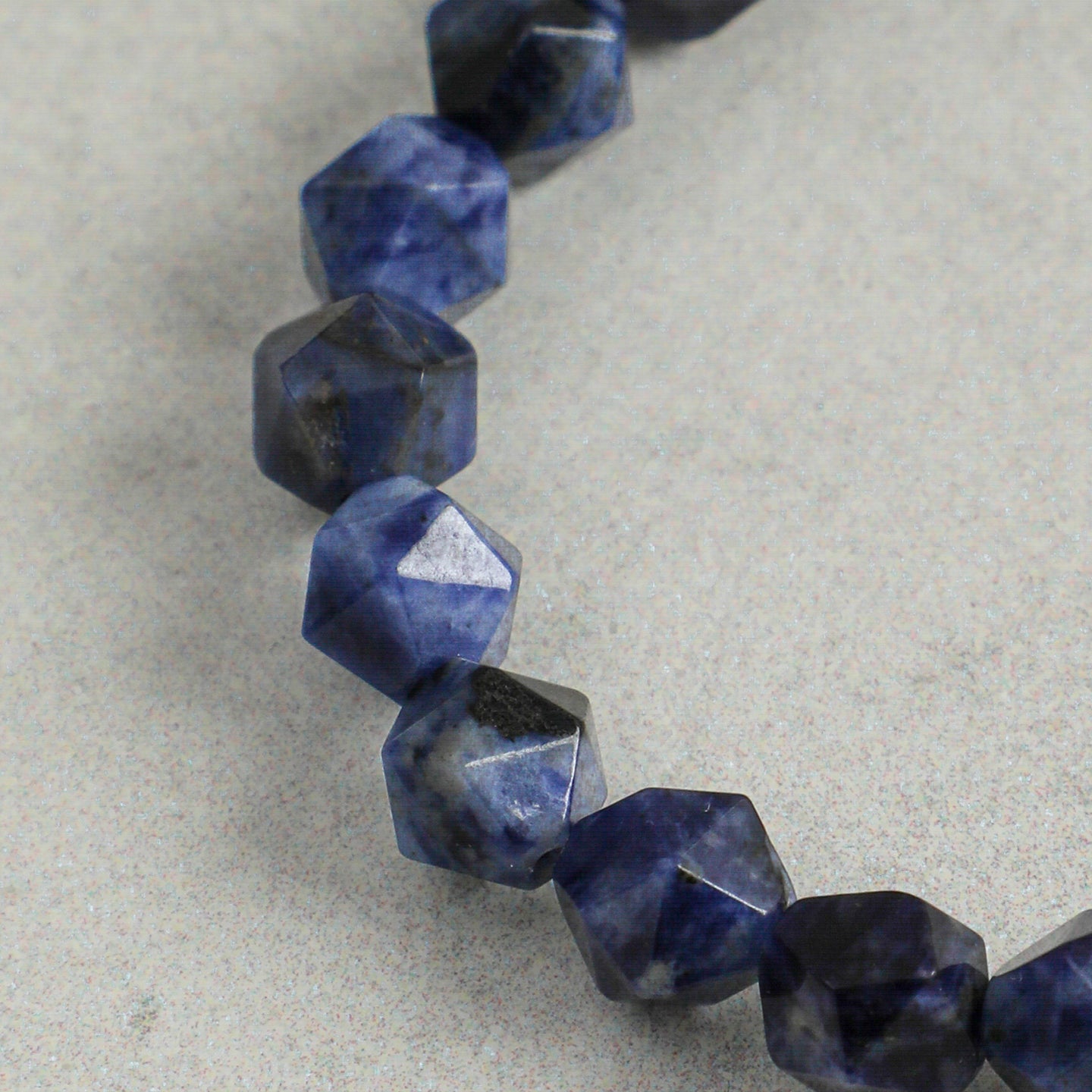 Close-up of faceted natural sodalite gemstones on handcrafted statement bracelet